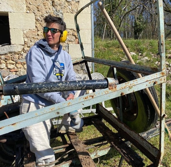 Sandra, casque anti-bruit sur les oreilles, transforme une vieille pastière en petite bétaillière. © Villages aux dames.