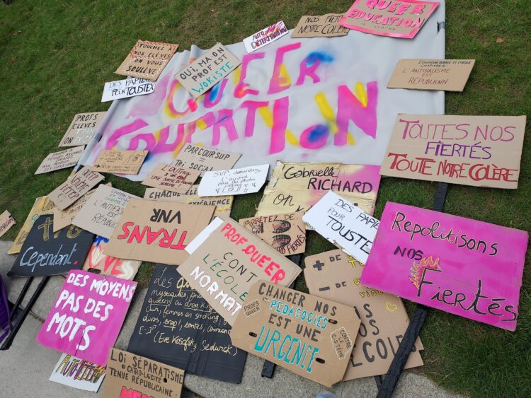 Des pancartes et une banderole réalisées par © Queer Education.