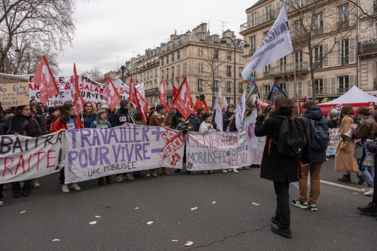  Manifestation à Paris contre la réforme des retraites 2023. Les manifestant-es brandissent une banderole : "Travailler + pour vivre - : non merci." © Franck Legros - Shutterstock 