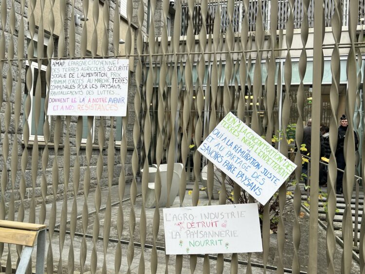 Des pancartes ont été accrochées sur la grille du tribunal. L'une d'elles fait la liste : "pollution de l'eau, destruction des sols, déforestation, algues vertes, pesticides, cancers, suicides des agriculteurs : merci pour les cadeaux l'agro-noël !" © Sarah Andres