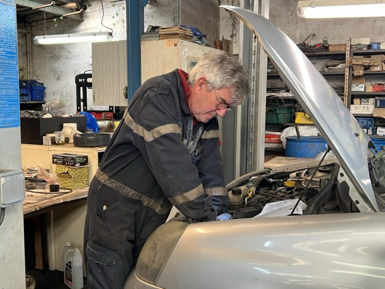 Le jour de notre interview, Alain, l'un des bénévoles mécaniciens réalise la vidange d'une Clio 2. © Sarah Andres / Lisbeth