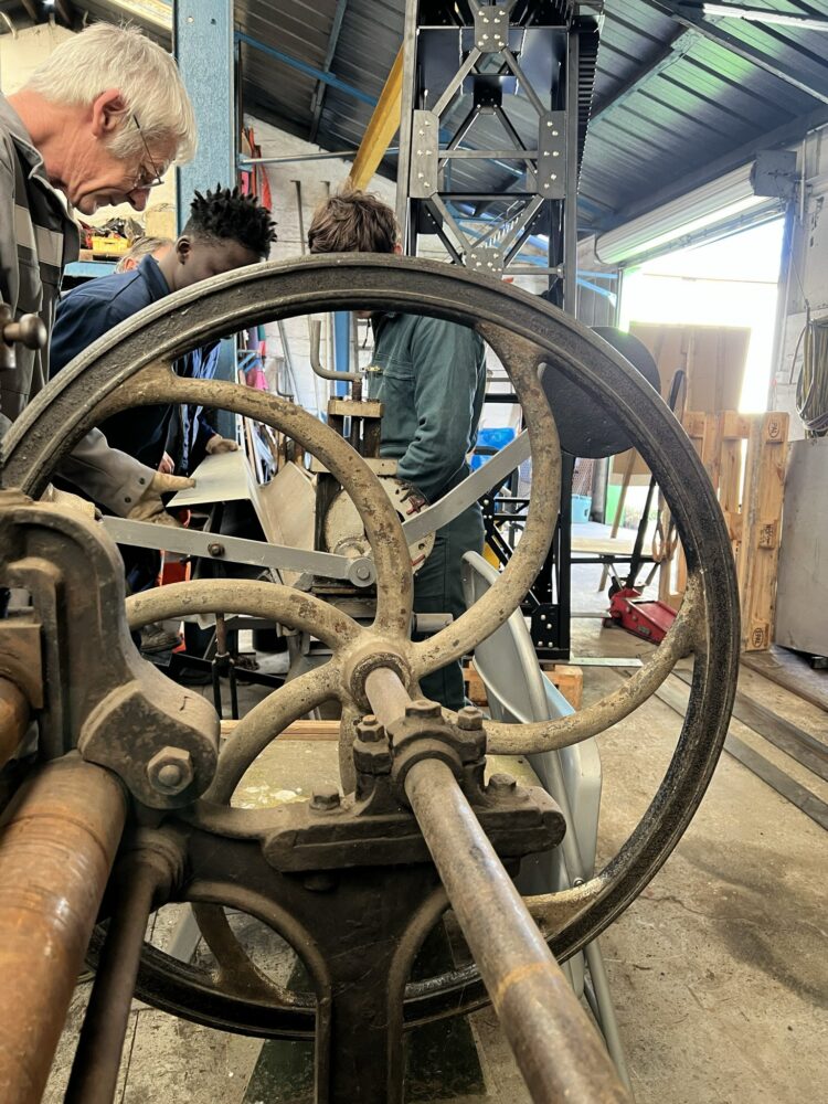 En haut : Le jour de notre venue, des jeunes "décrocheurs" suivent une formation en tôlerie. En bas : Le jour de notre venue à la Caisse à clous, les bénévoles de la commission menuiserie encadrent les résident-es d'un Ehpad pour un atelier. © Sarah Andres / Lisbeth